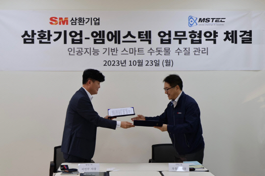 엠에스텍 대표이사 이민수(왼쪽)와 SM그룹 삼환기업 대표이사 유창훈(오른쪽)이 지난 23일, 'AI 기반 스마트 수돗물 수질 측정 시스템'을 도입하는 업무 협약을 맺고 협약서를 교환하고 있다.   [엠에스텍 제공]